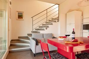 a living room with a red dining room table and stairs at Appartamento Il Nespolo in Pontedera +17 photos