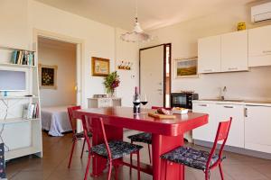 a red table in a kitchen with red chairs at Appartamento Il Nespolo in Pontedera