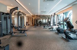 a gym with several treadmills and machines in a room at Legendary 2 Bdr Comfort in Bang Tao Beach