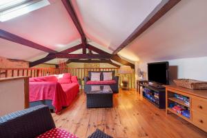 a living room with a bed and a flat screen tv at Gite Le Mas in Corgnac-sur-lʼIsle