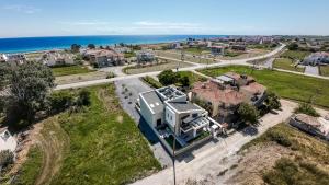 an aerial view of a house with the ocean in the background at Trithiron Luxury Villas in Nea Moudania