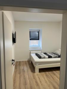 a small bedroom with a bed and a window at Ethical Choice Residence in Kaiserslautern