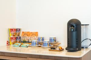 Eine Kaffeemaschine auf einer Theke mit Tellern und Tassen. in der Unterkunft Hotel Yeon in Seogwipo + 65 Fotos