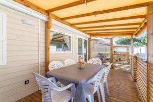 a dining room with a table and white chairs at Bungalow in Canet-en-Roussillon