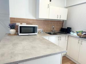 a kitchen with a microwave and a sink at Studio with private kitchenette and bathroom in Leumeah