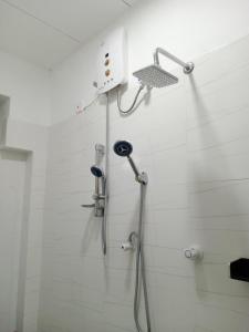 a shower in a white bathroom with a shower at Vintage rooms in Dickwella