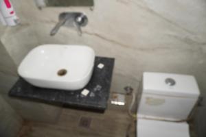 a bathroom with a white sink and a toilet at Hotel Moon Mahal in Jaipur +14 photos