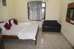 a bedroom with a bed and a chair and a window at Hotel Moon Mahal in Jaipur