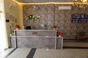 a reception desk in a room with a floral wall at Hotel Moon Mahal in Jaipur