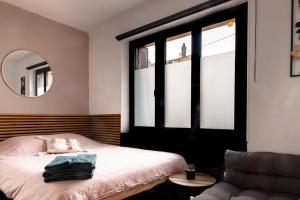 a bedroom with a bed and a mirror and a chair at Studio Cocoon in Colombey-les-Belles +1 photo