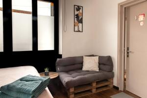 a living room with a couch and a bed at Studio Cocoon in Colombey-les-Belles