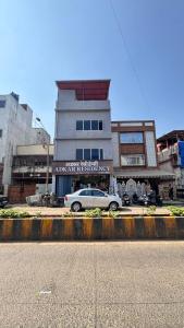 a white car parked in front of a building at Hotel Adkar Residency Borivali West in Mumbai