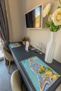 a table with a vase of flowers on it with a vase at Athena Charming Rooms in Taormina +54 photos