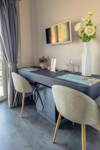 a blue desk with two chairs and a vase with flowers at Athena Charming Rooms in Taormina
