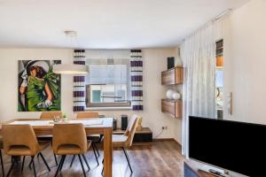 a dining room with a dining table and a tv at Ferienhaus Eisfelder Blick in Eisfeld