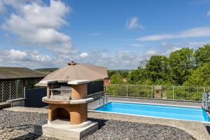 a swimming pool with an umbrella next to a swimming pool at Ferienhaus Eisfelder Blick in Eisfeld