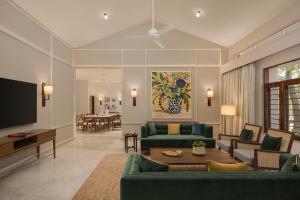 a living room with two green couches and a tv at Oasis County Villas in Bangalore