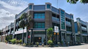 a large building with palm trees in front of it at Tekoma Hotel Ipoh - Dandelion Inn in Simpang Pulai