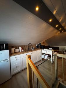 a kitchen with white cabinets and a white refrigerator at Bjarmaland in Vestmannaeyjar