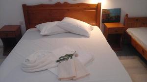 un letto con due asciugamani e due cuscini sopra di O Fotis ad Agios Prokopios