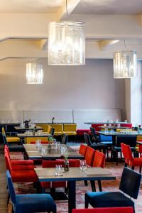 a dining room with tables and chairs and chandeliers at VICTORIA Hotel Kaunas in Kaunas