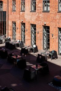 a group of tables in front of a brick building at VICTORIA Hotel Kaunas in Kaunas