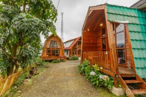 a row of wooden homes with trees and a pathway at Villa Ira Dieng in Diyeng