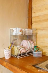 a dish rack with plates and other dishes on a counter at Villa Ira Dieng in Diyeng