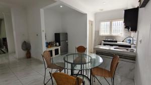 a kitchen with a glass table and chairs at Villa Dalia Puncak N5-10 in Cikundul