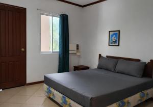 a bedroom with a bed and a window and a door at Kyleville Resort by Hiverooms in Dalaguete