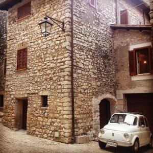 an old car parked in front of a stone building at Lelive Bed and Breakfast in Sermoneta