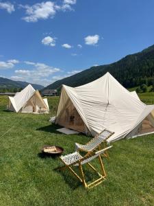 a couple of tents and a chair in the grass at Wiesn Relax Camping Steiner in Ranten