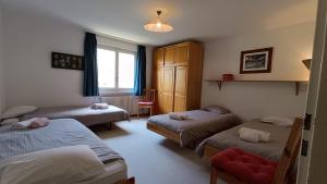 a room with three beds and a window at Panorama 14 in Bagnes