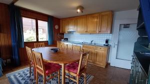 a kitchen with a wooden table and chairs and a sink at Panorama 14 in Bagnes