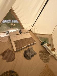 a tent with a bed and other items in it at Wiesn Relax Camping Steiner in Ranten