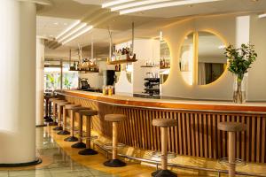eine Bar mit einer Reihe von Barhockern in einem Restaurant in der Unterkunft Hotel Helios Lloret in Lloret de Mar