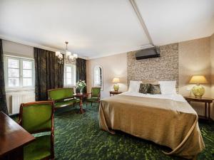 a hotel room with a bed and a table and chairs at Platán Utca - Platán Tata in Tata