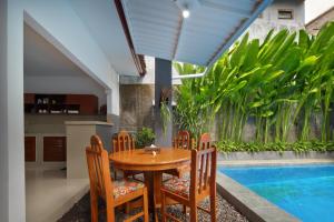 a dining room with a table and chairs and a pool at Hildiman Villa Kuta - Two Bedroom Private pool in Kuta