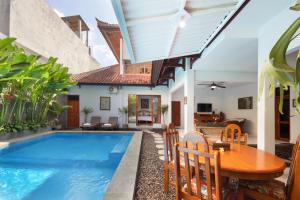 a villa with a swimming pool and a table and chairs at Hildiman Villa Kuta - Two Bedroom Private pool in Kuta