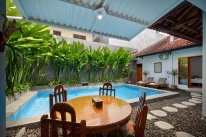 a patio with a table and chairs next to a pool at Hildiman Villa Kuta - Two Bedroom Private pool in Kuta +22 photos