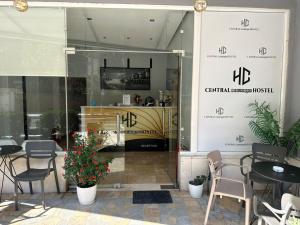 a restaurant with tables and chairs and a glass door at Central Boutique Hostel in Sarandë