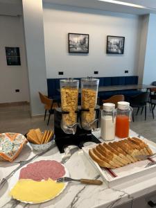 a table with some food and some drinks and snacks at Central Boutique Hostel in Sarandë