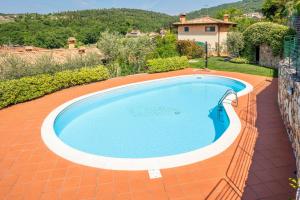 a swimming pool in a yard with a house at Stella di Castion in Costermano