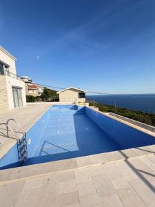 a blue swimming pool with the ocean in the background at Villa Max in Krimovice