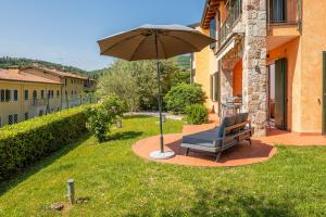 a chair sitting under an umbrella in a yard at Stella di Castion in Costermano