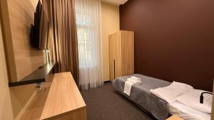 a small room with a bed and a window at Готель Гоголь in Poltava