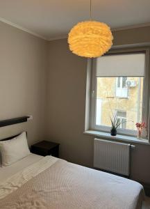 a bedroom with a bed and a window and a chandelier at Hotel Dolynskiy in Lviv +50 photos