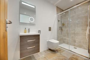 a bathroom with a toilet and a glass shower at The Coach House in Alnwick +43 photos