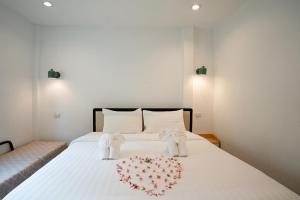 a bedroom with a white bed with a heart on it at Dream Villa Beachside Sunset in Ban Bang Po