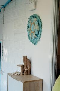 a wreath hanging on a white wall with a wooden shelf at Dream Villa Beachside Sunset in Ban Bang Po